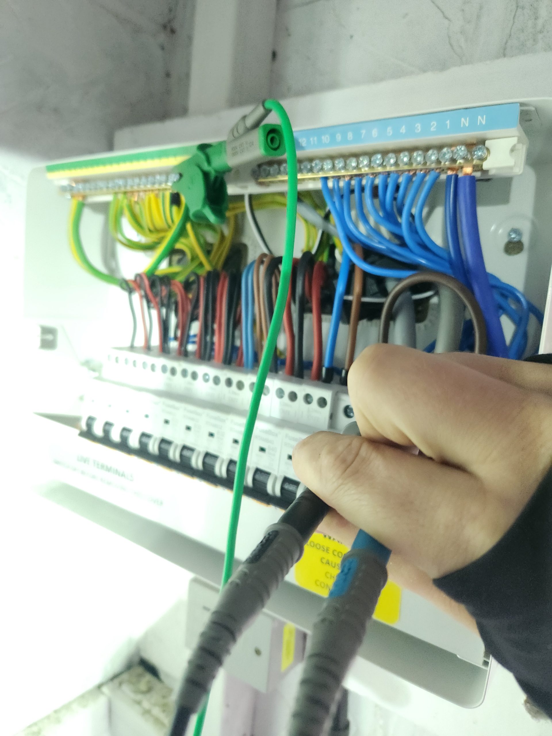 Electrician rewiring a house with green electrical cable exposed