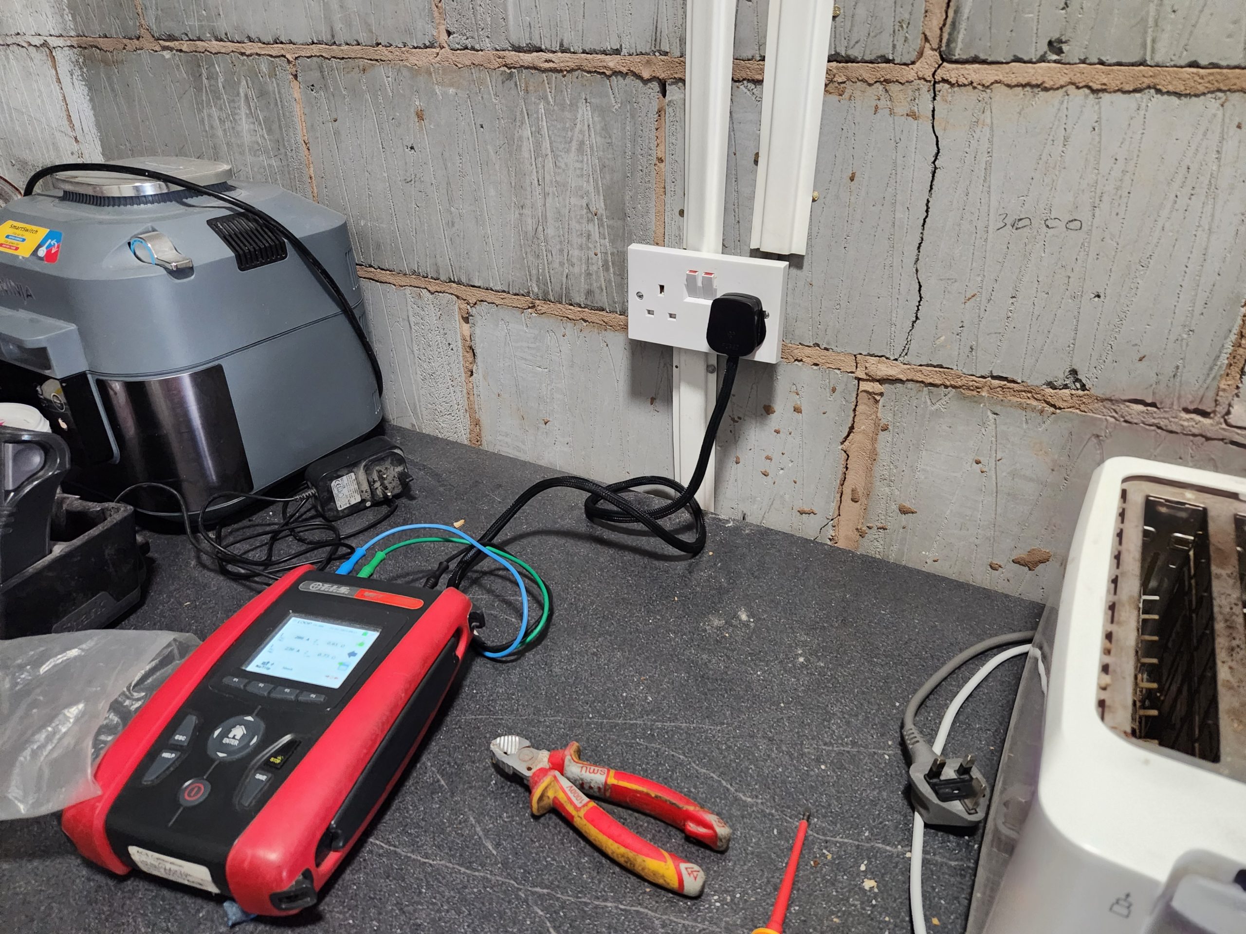 HudsonsElec using electrical measurement device in kitchen