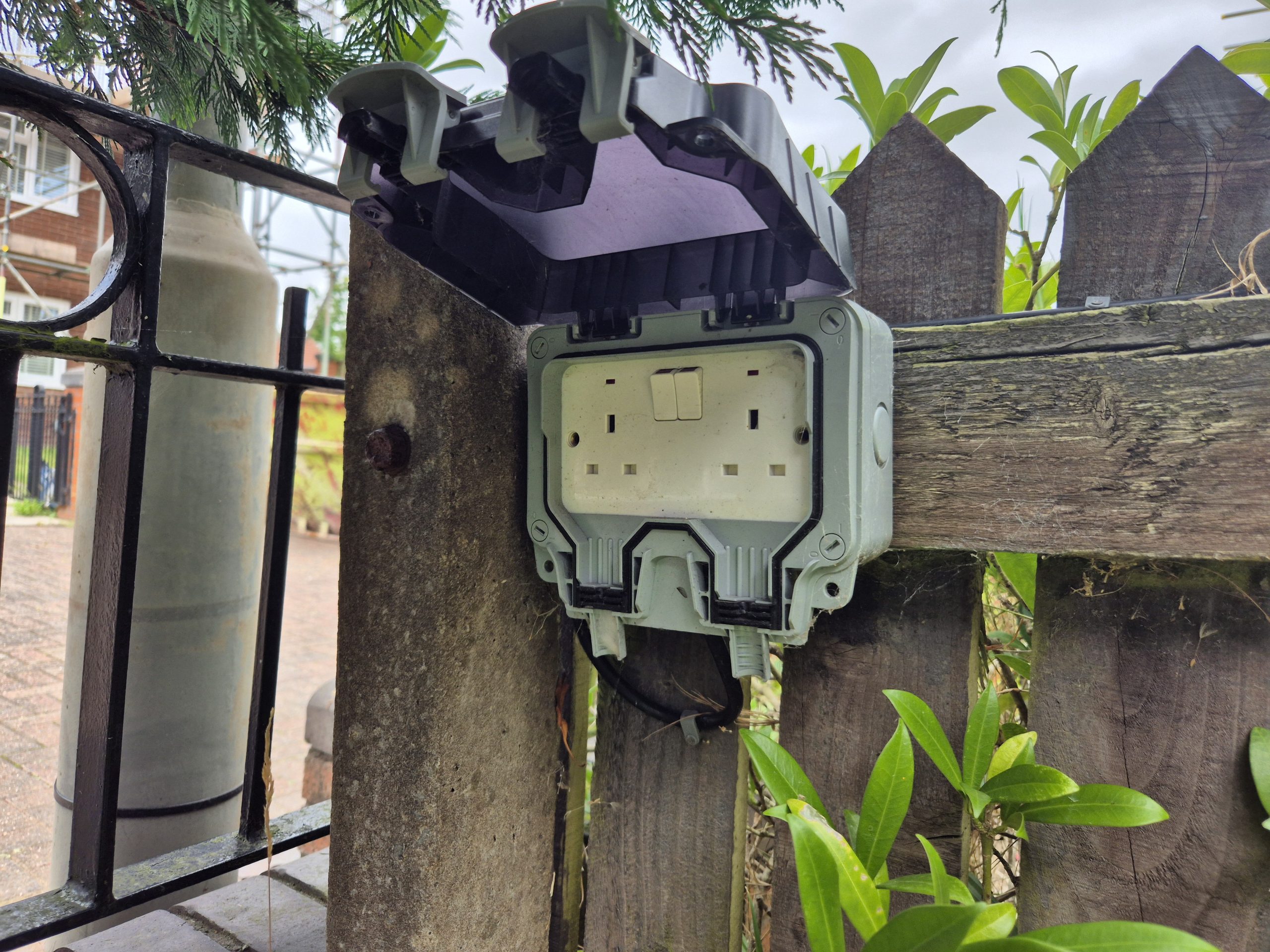 Electrician rewiring a house with green electrical cable exposed